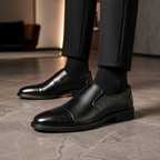 Lucca Cap-Toe Brogue Loafer in black, worn
