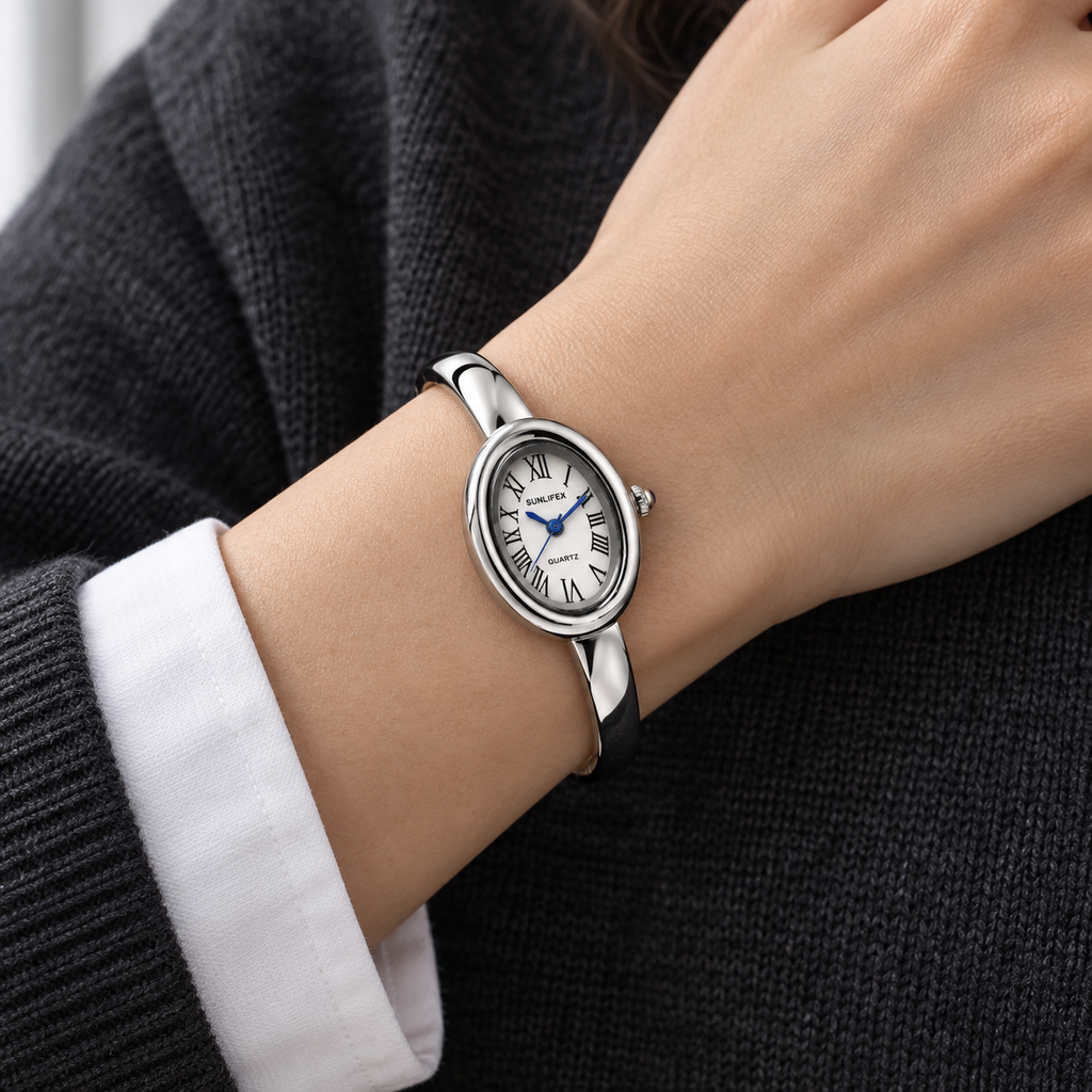 Aurelia Bracelet Watch in Silver worn with a white cuff and charcoal knit