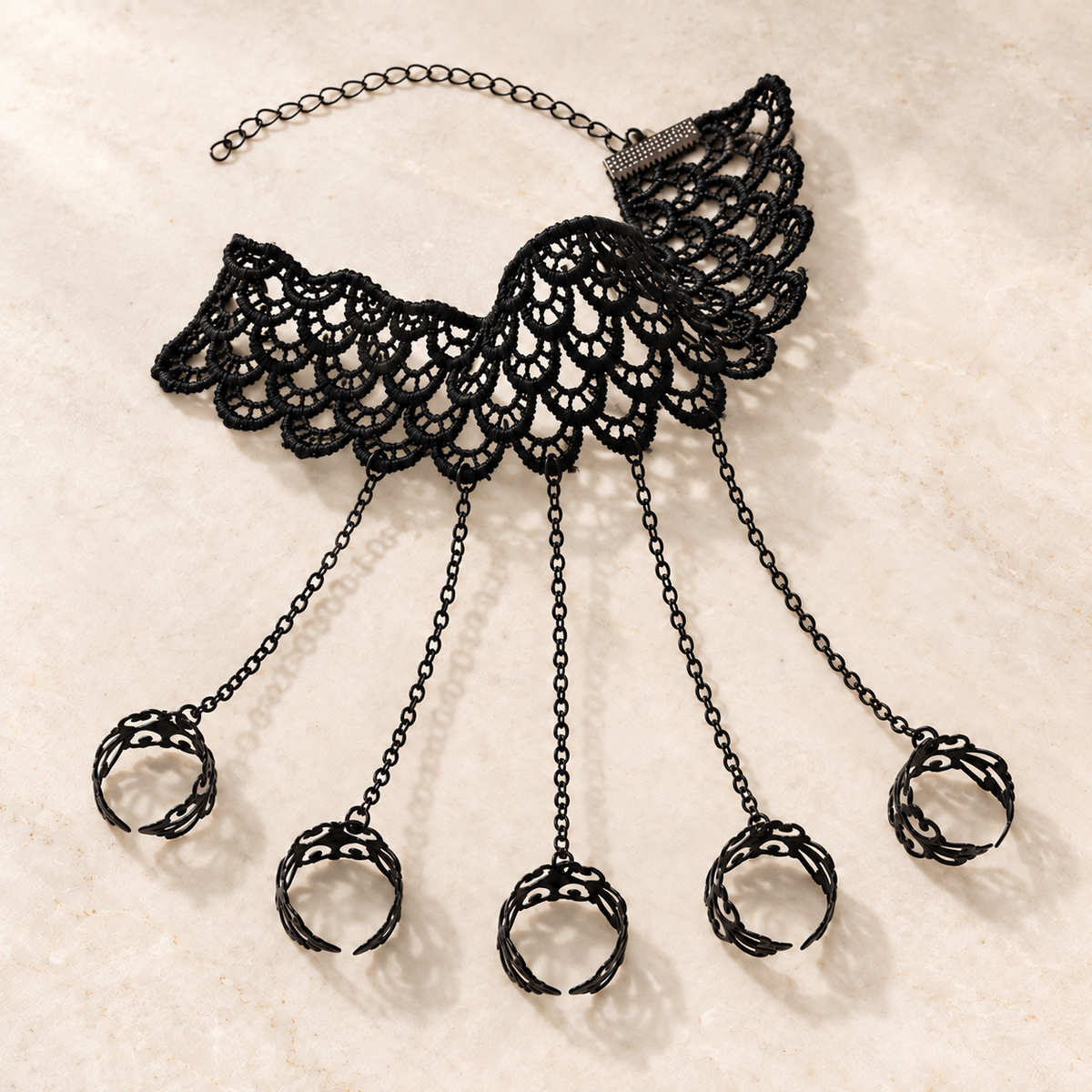 Noemi Hand Chain flat lay with five filigree rings and adjustable black lace cuff
